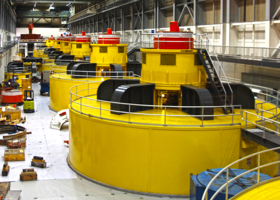 Large yellow hydroelectric generator turbines inside the Glen Canyon Dam power plant