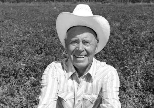 Old black and white photo of J R Simplot in a potato field in southeaster Idaho