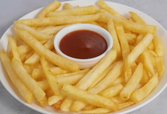 Golden french fries served with a side of ketchup on a white plate