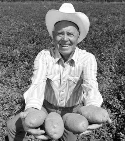 J. R. Simplot, the Idaho potato pioneer, holding large fresh potatoes