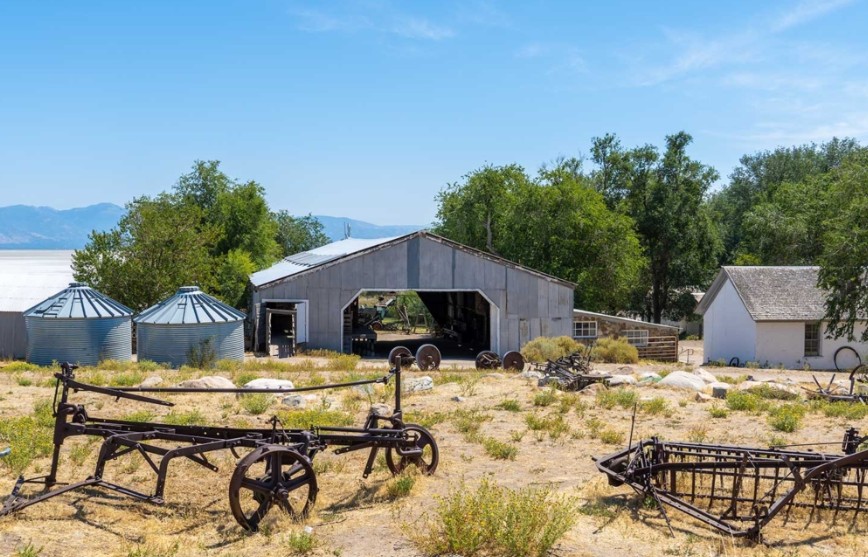 Old farm and raching equipment at the Fielding Garr Ranch on Antelope Island State Park. Ranch house on the right and sheep shearing barn on the left.