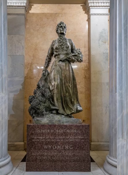 Full length bronze statue of Esther Hobart Morris standing on a granite pedestal inside the United States Capitol Hall of Columns