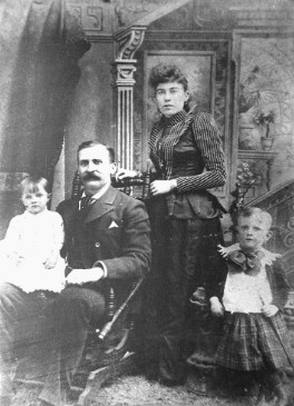 Vintage Victorian family portrait of Margaret Molly Brown standing with her husband J.J. Brown and their two young children, Lawrence and Helen, in a photography studio.