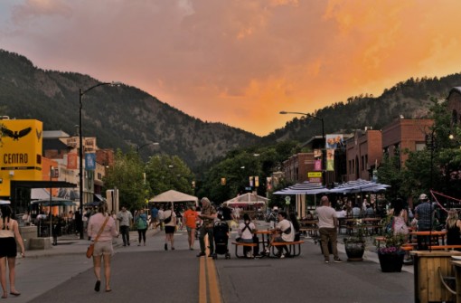 Crowd gathered at an outdoor street festival during a vibrant sunset in Colorado.