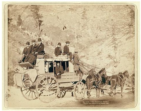 Vintage sepia photograph of a horse-drawn stagecoach carrying passengers in historic Colorado.