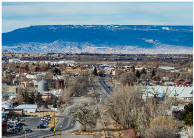 High angle view of Montrose Colorado with the snow-dusted Grand Mesa in the background.