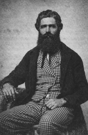 Historical black-and-white studio portrait of a bearded man (believed to be Jacob Waltz) seated.