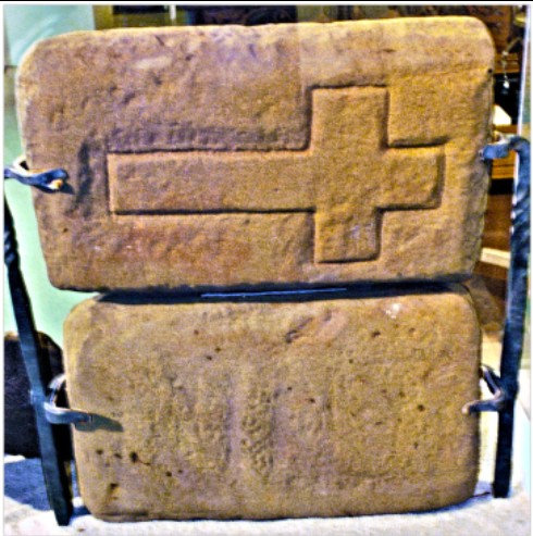 Reverse side of the stone slabs displaying a large, raised cross design.