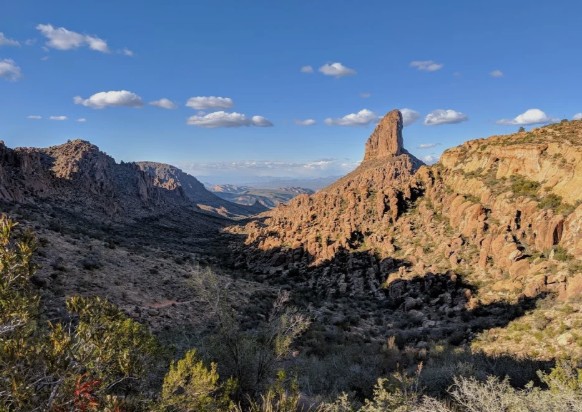 Looking across a desert canyon toward the prominent rock pinnacle of Weaver's Needle.