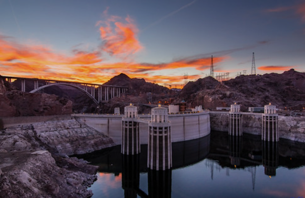 Color photograph of a sunset over Hoover Dam in southwestern Nevada.