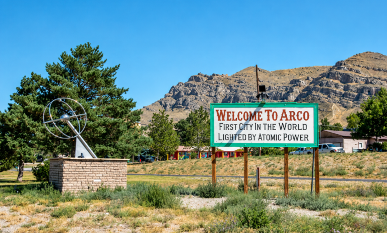Welcome to Arco, Idaho sign with mountains in the background