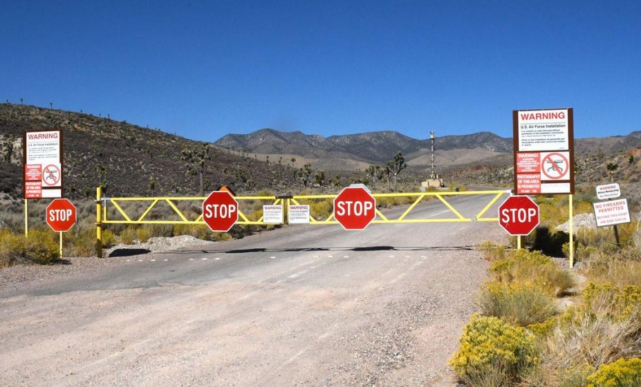Area 51 main entrance gate and security warning signs on Groom Lake Road in the remote Nevada desert.