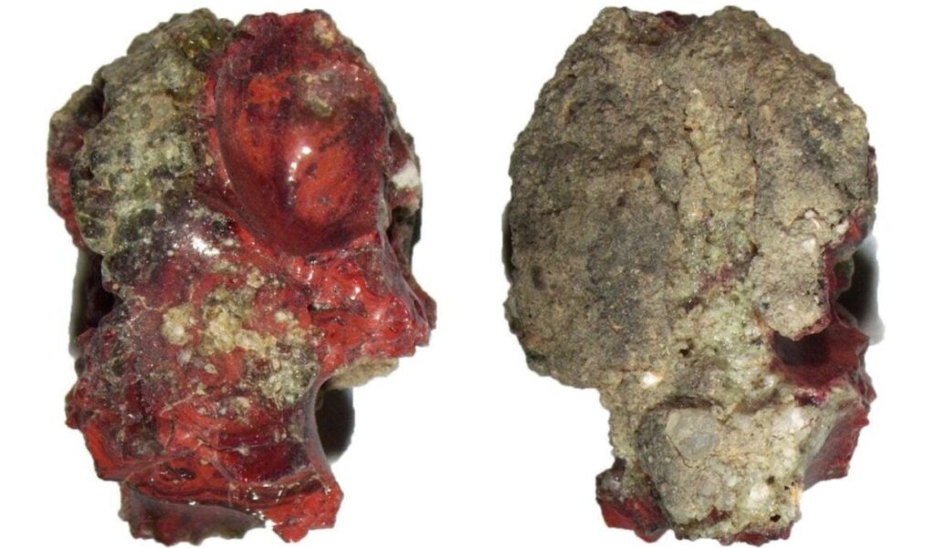 Red Trinitite glass from the 1945 Trinity atomic bomb test in New Mexico, containing a rare quasicrystal discovered by scientists in 2021.
