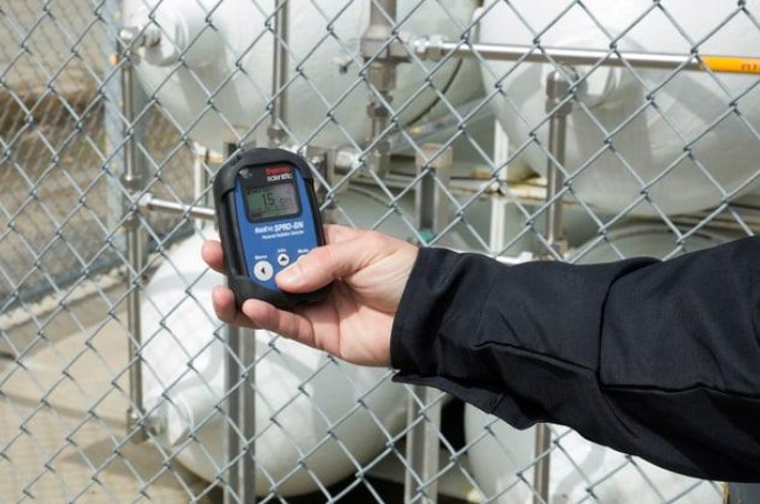 Handheld Thermo Scientific radiation detector used to identify radioactive materials, similar to equipment used to examine Trinitite glass.